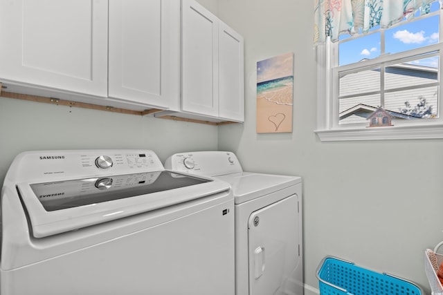 clothes washing area featuring cabinets and washing machine and dryer