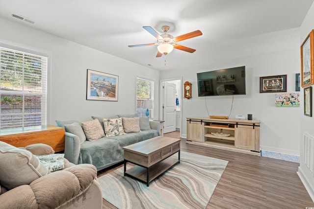 living room featuring ceiling fan and dark hardwood / wood-style flooring