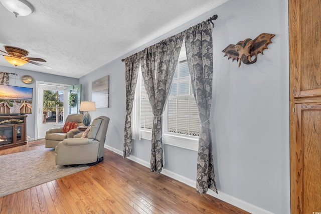 310 34th Ave N, North Myrtle Beach, SC 29582 - living area with a textured ceiling, light wood-type flooring, a ceiling fan, and baseboards