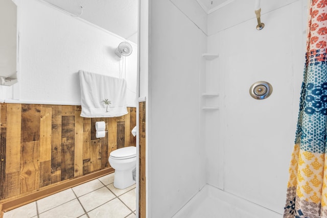 bathroom with tile patterned floors, wood walls, toilet, and walk in shower