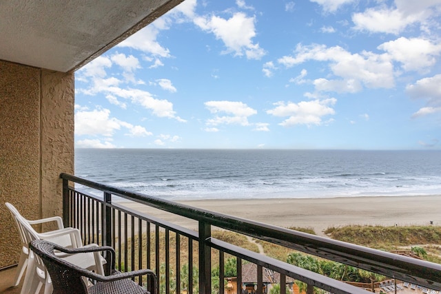 balcony featuring a water view and a beach view