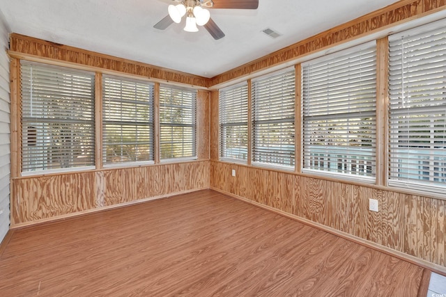 unfurnished sunroom featuring ceiling fan