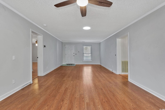 spare room with a textured ceiling, light hardwood / wood-style flooring, ceiling fan, and ornamental molding