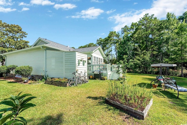 view of side of home featuring a lawn and a wooden deck