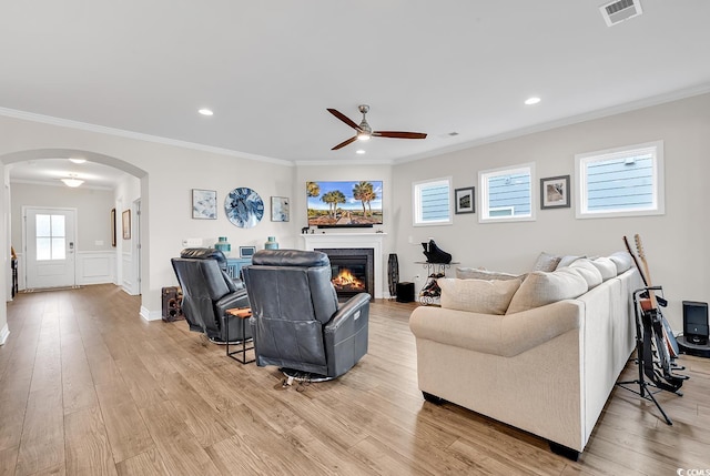 living room with light hardwood / wood-style flooring, ceiling fan, and crown molding