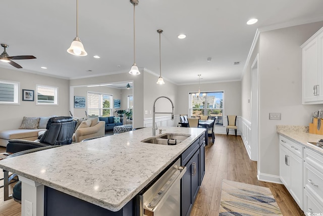 kitchen featuring ceiling fan, white cabinetry, sink, and hanging light fixtures