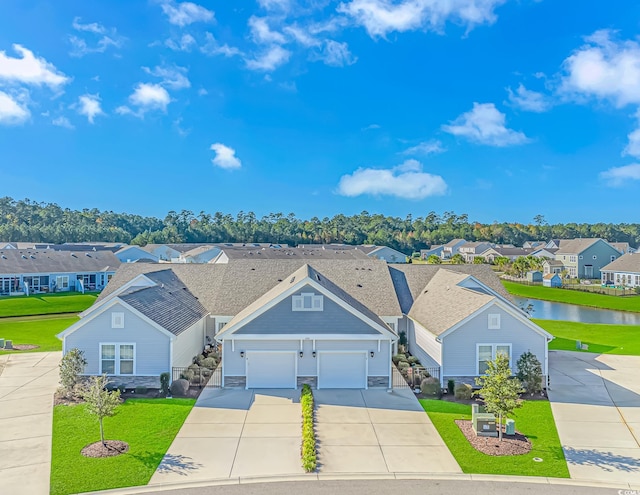 view of front facade featuring a front yard, a garage, and a water view