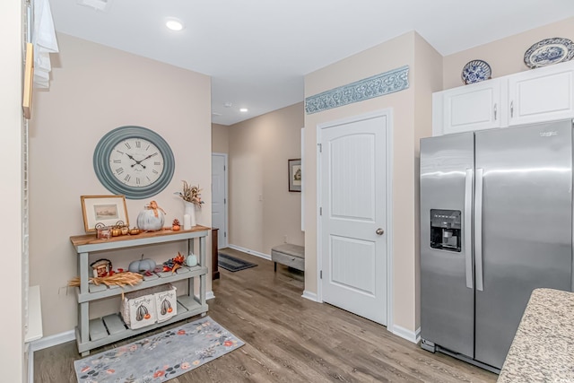 kitchen featuring white cabinets, light wood-type flooring, and stainless steel fridge