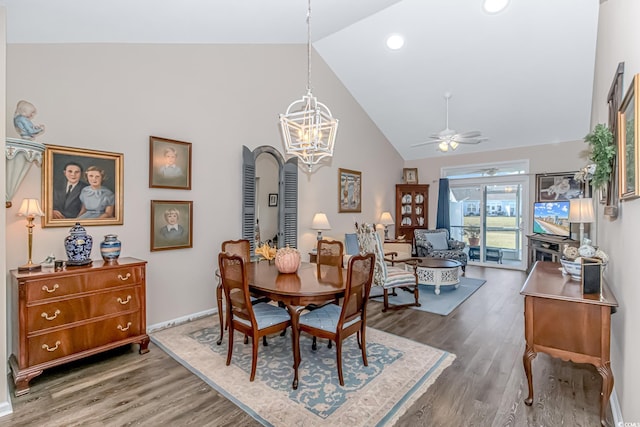 dining room featuring hardwood / wood-style floors, vaulted ceiling, and ceiling fan with notable chandelier