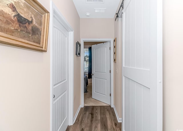 hall featuring hardwood / wood-style floors and a barn door