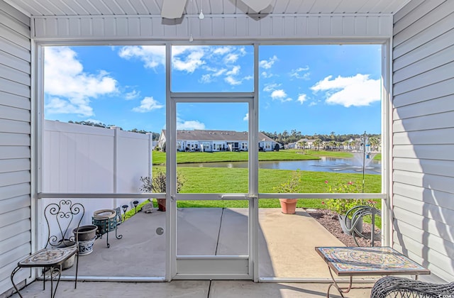 sunroom featuring a water view