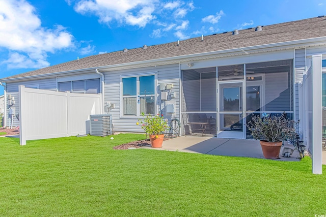 rear view of house with a lawn, cooling unit, and a patio