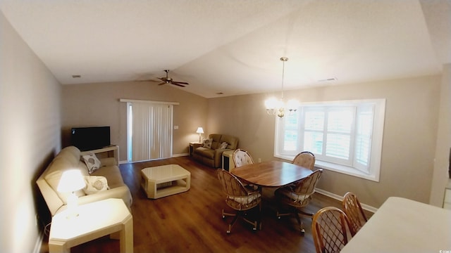 dining space with dark hardwood / wood-style flooring, ceiling fan with notable chandelier, and lofted ceiling