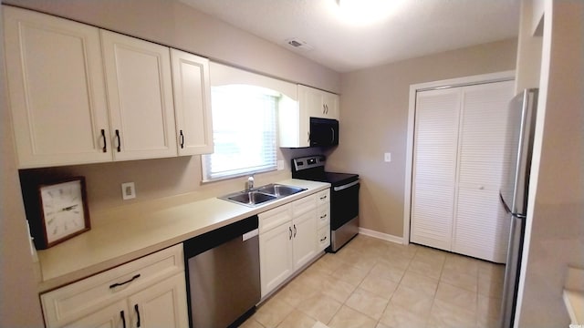 kitchen with light tile patterned floors, white cabinetry, sink, and appliances with stainless steel finishes