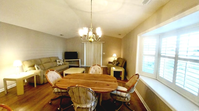 dining room featuring plenty of natural light, hardwood / wood-style floors, lofted ceiling, and a notable chandelier