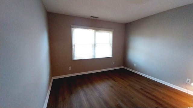 empty room with dark wood-type flooring