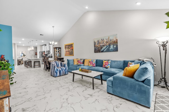 living room with a notable chandelier and lofted ceiling