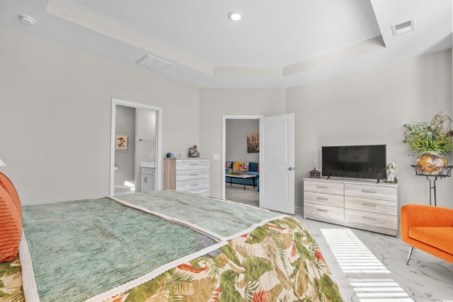 bedroom with a tray ceiling and ensuite bath