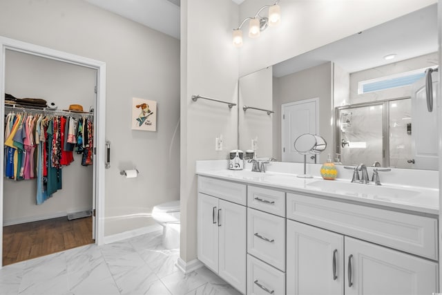 bathroom with vanity, a shower with shower door, and toilet