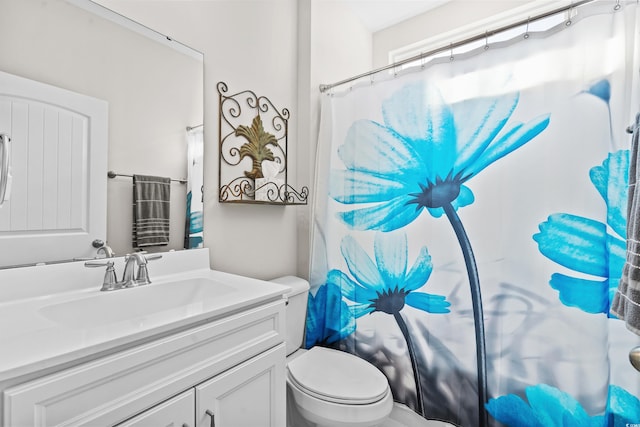 bathroom with walk in shower, vanity, and toilet