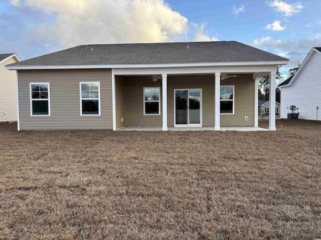 rear view of house with ceiling fan, cooling unit, a yard, and a patio