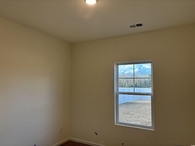 unfurnished room with carpet flooring and a water view