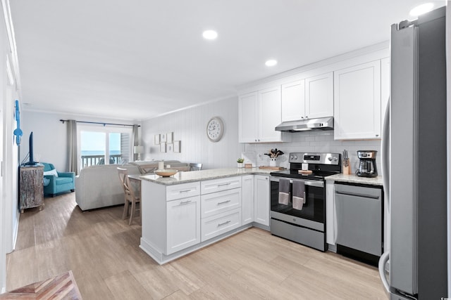 kitchen with white cabinetry, kitchen peninsula, ornamental molding, and appliances with stainless steel finishes