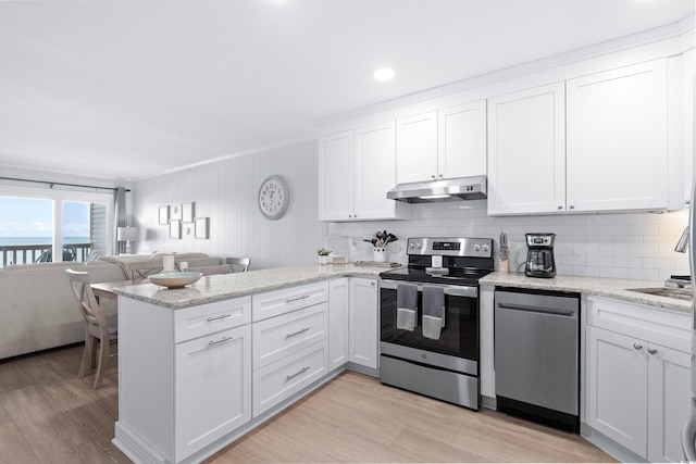 kitchen with white cabinets, light wood-type flooring, kitchen peninsula, and stainless steel appliances