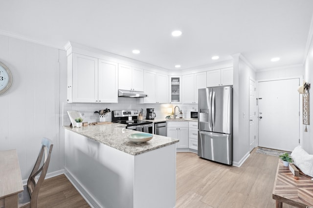 kitchen with sink, stainless steel appliances, light hardwood / wood-style flooring, kitchen peninsula, and white cabinets