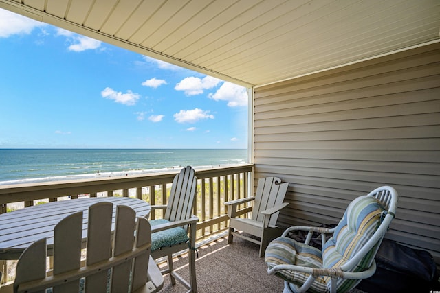 balcony featuring a beach view and a water view