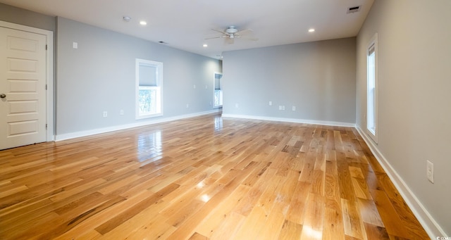 empty room with ceiling fan and light hardwood / wood-style floors