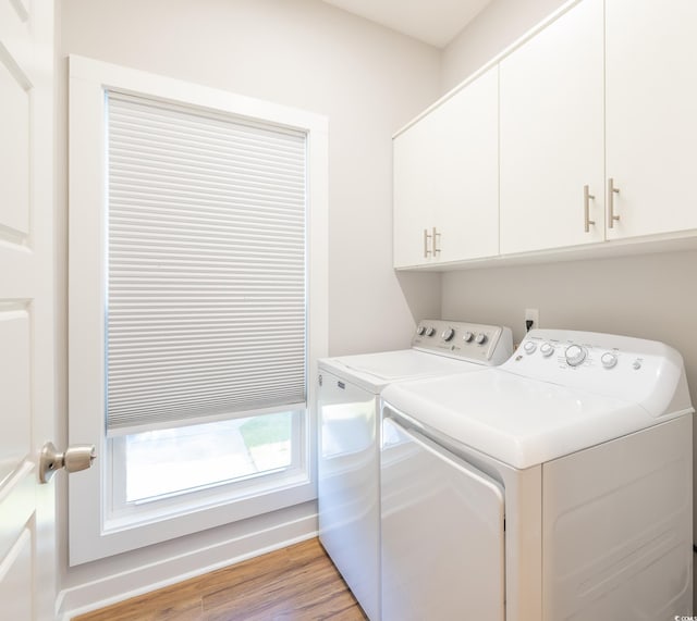 laundry room featuring cabinets, separate washer and dryer, and light hardwood / wood-style floors