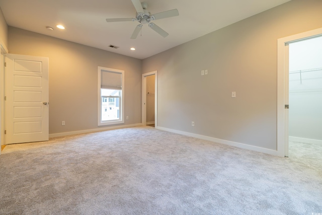 spare room with ceiling fan and light colored carpet