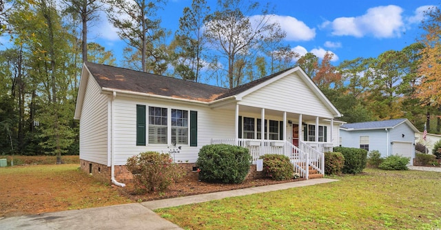 view of front of property with an outbuilding, a porch, crawl space, a garage, and a front lawn