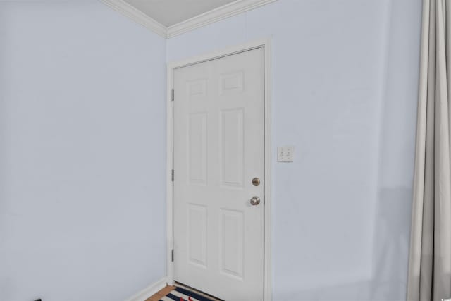 doorway featuring ornamental molding and baseboards