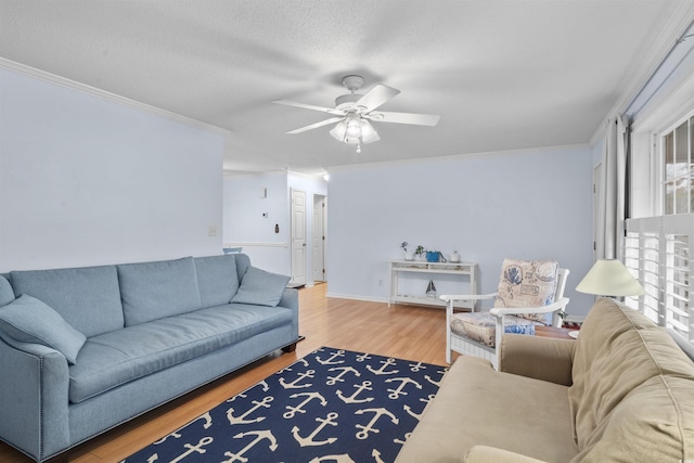 living room featuring ornamental molding, ceiling fan, a textured ceiling, and wood finished floors