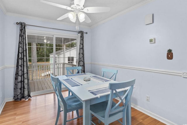 dining space featuring a ceiling fan, baseboards, ornamental molding, and wood finished floors