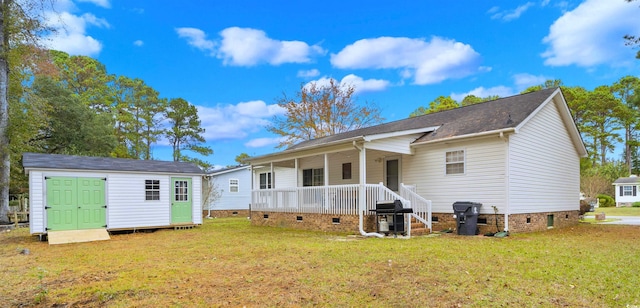 back of property with an outbuilding, a yard, a storage unit, covered porch, and crawl space