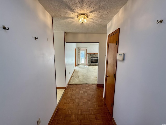 hall featuring dark parquet flooring and a textured ceiling