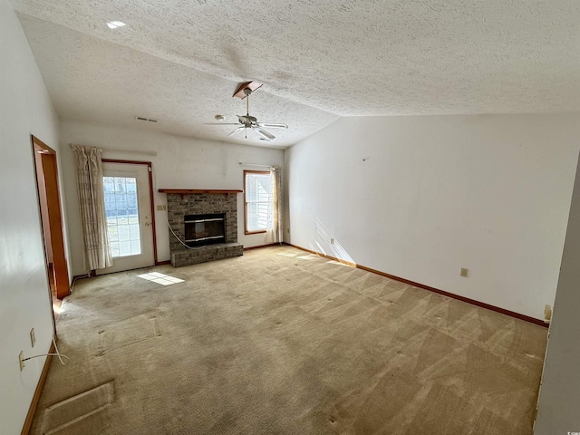 unfurnished living room with ceiling fan, a fireplace, lofted ceiling, and a textured ceiling