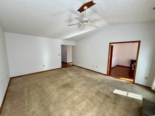 unfurnished room with ceiling fan, light colored carpet, a textured ceiling, and vaulted ceiling