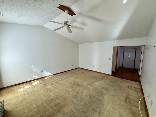 interior space with a textured ceiling, vaulted ceiling, and ceiling fan