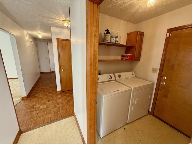 washroom featuring cabinets, independent washer and dryer, a textured ceiling, and light parquet flooring