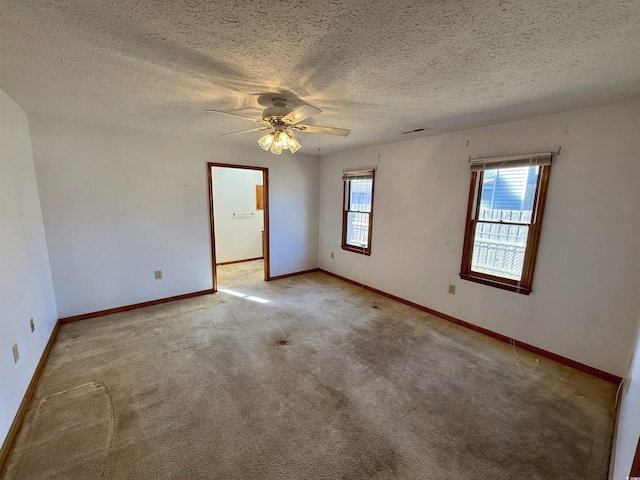 carpeted empty room with ceiling fan and a textured ceiling