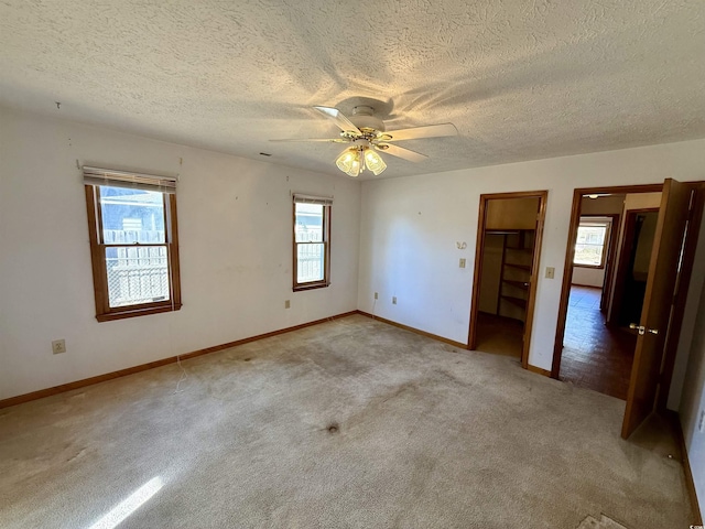 carpeted empty room featuring a textured ceiling and ceiling fan