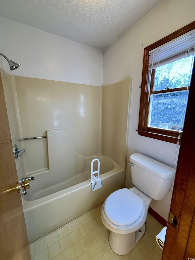 bathroom featuring bathtub / shower combination, a textured ceiling, and toilet