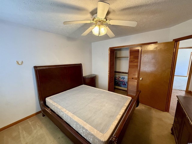 carpeted bedroom featuring a textured ceiling, a closet, and ceiling fan