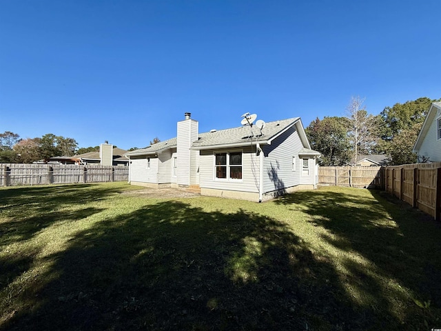 rear view of property featuring a lawn