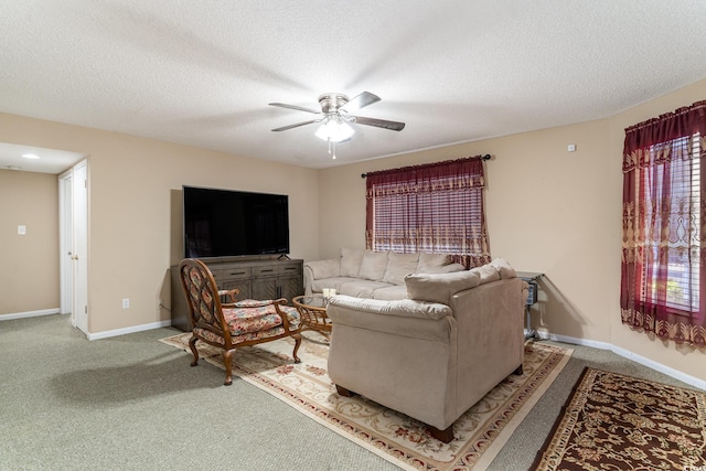 living room featuring carpet, ceiling fan, and a textured ceiling