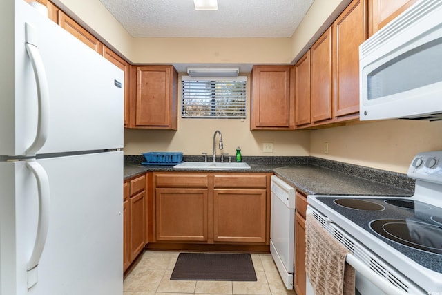 kitchen with a textured ceiling, white appliances, light tile patterned floors, and sink